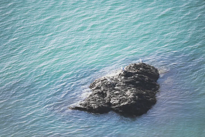 Rock in the blue sea — photograph by Monty Bray