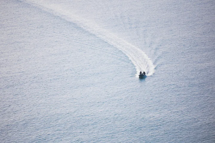 Boat wake on calm water — photograph by Monty Bray