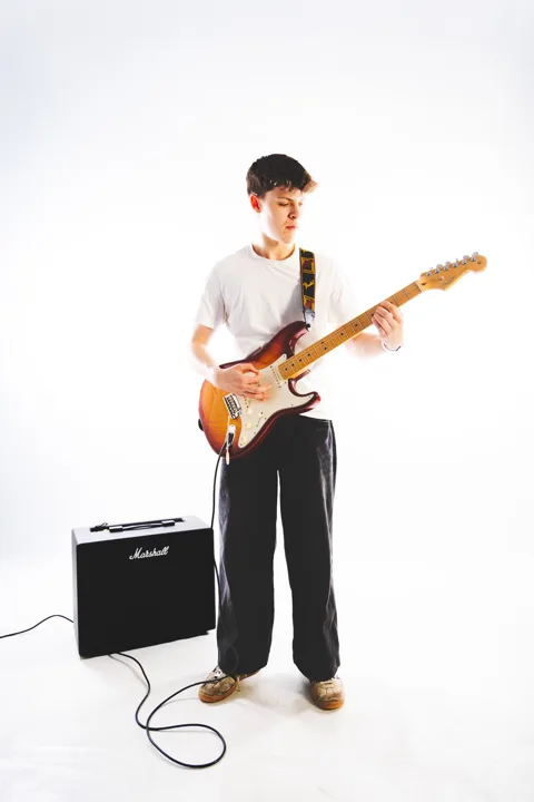 Dark-haired guitarist, studio — photograph by Monty Bray