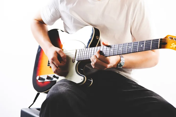 Dark-haired guitarist, studio — photograph by Monty Bray