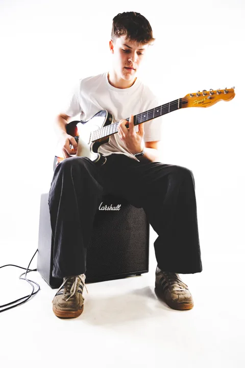 Dark-haired guitarist, studio — photograph by Monty Bray
